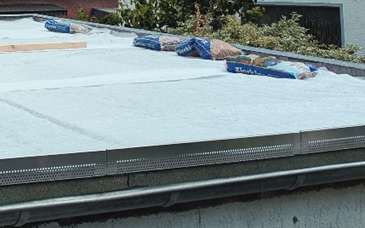 Aufsicht auf ein Flachdach mit ausgelegtem Filtervlies während der Umsetzung einer Dachbegrünung