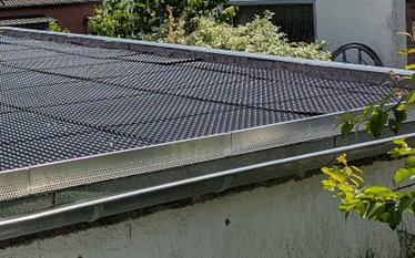 Aufsicht auf ein Flachdach mit ausgelegten Drän- und Wasserspeicherelementen während der Umsetzung einer Dachbegrünung