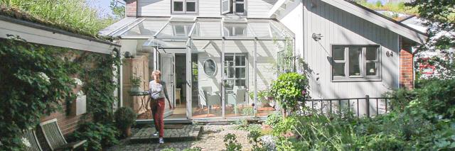 Beispiel Vorgarten mit Frau, die aus Haus kommt