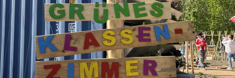 Holzschild mit der Aufschrift Grünes Klassenzimmer in bunten Buchstaben