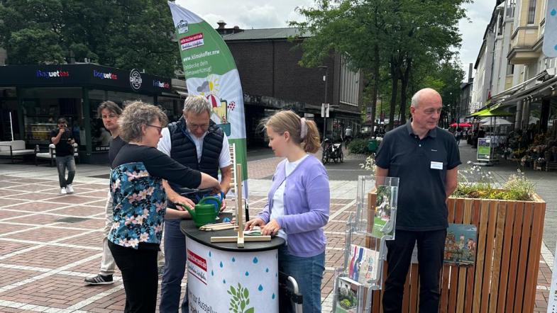 Infostand an der Ausstellung mit interessierten Personen und Beratungspersonal