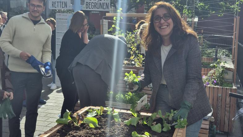 Fatma Özkan (Leiterin Gruppe Klimaanpassung VZ NRW) bepflanzt ein Hochbeet